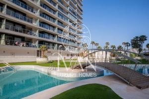 eine Brücke über einen Pool vor einem Gebäude in der Unterkunft Casa Andrea Ivan Luxury Homes 4ªPlta Sur 1ªLínea in Oropesa del Mar