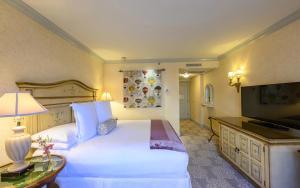 una camera d'albergo con letto bianco e TV di Delamar Greenwich Harbor a Greenwich