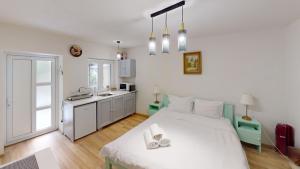 a bedroom with a large white bed and a kitchen at Tischler Studio VRT in Sibiu