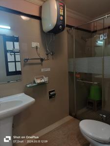 a bathroom with a shower and a toilet and a sink at Yarlam Portico in Gangtok