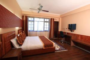 a hotel room with a bed and a television at Yarlam Portico in Gangtok