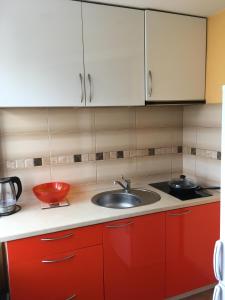a kitchen with red cabinets and a sink at Apartment on the 4th floor in Jūrmala