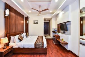 a bedroom with a bed and a flat screen tv at Pinaz Royale in Amritsar