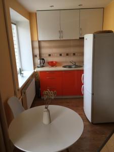 a kitchen with a white table and a white refrigerator at Apartment on the 4th floor in Jūrmala