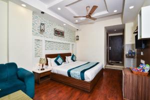 a bedroom with a bed and a blue couch at Pinaz Royale in Amritsar
