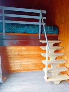 a staircase in a room with a bunk bed at Chalet idéal 4-8 pers avec garage 20 mn Gérardmer in Vienville