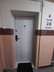 a white door in a building with a sign on it at Apartament Superjednostka in Katowice