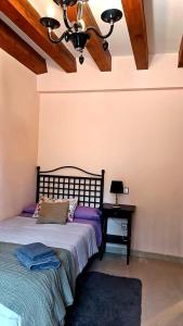 - une chambre avec un lit et un lustre dans l'établissement El Rincon De Luna, à Moratilla de los Meleros