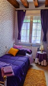 - une chambre avec 2 lits et des rideaux violets dans l'établissement El Rincon De Luna, à Moratilla de los Meleros