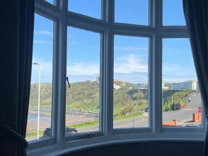 ventana con vistas a la playa y al océano en Hotel Ellenby en Scarborough