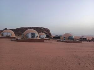 a group of three domes in the desert at Wadi Rum Maracanã camp in Wadi Rum