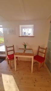 a dining room table with two chairs and a vase on it at Wohnen in Niederweimar zwischen Marburg und Gießen in Niederweimar +2 photos