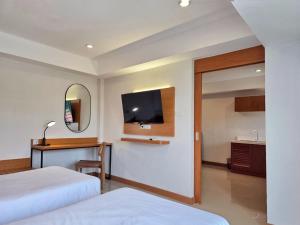 Habitación de hotel con 2 camas y TV de pantalla plana. en Wangkaew Hotel, en Phitsanulok