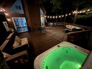 une baignoire jacuzzi sur la terrasse d'une maison dans l'établissement Luxury Family Escape HotTub Sauna Billiard Pool home, à East Stroudsburg