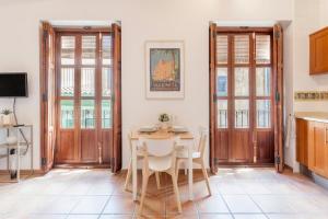a kitchen and dining room with a table and chairs at Sunny Modern Flat by Mercado Central in Valencia