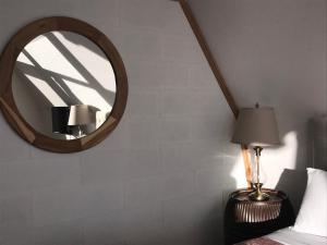 Alonnah的住宿－The Roundhouse-Waterfront Stay，一间带镜子、一张床和一盏灯的卧室