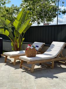 zwei Liegestühle und eine Bank auf einer Terrasse in der Unterkunft Shome in Vilanova i la Geltrú