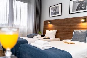 una camera d'albergo con due letti e un bicchiere di birra di Sleep Port a Danzica