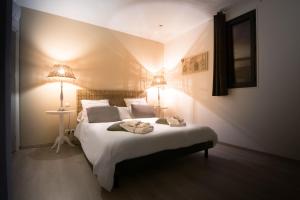 ein Schlafzimmer mit einem großen weißen Bett mit zwei Lampen in der Unterkunft B&B Maison d'hôte et gite Mas d'Eymard in Arles