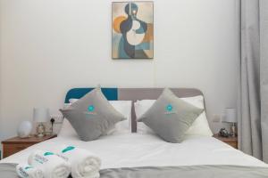 Bloomfields -1br Oasis 2 في أبوظبي: سرير عليه أغطية ووسائد بيضاء