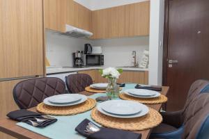 Bloomfields -1br Oasis 2 في أبوظبي: طاولة عليها صحون و ورد في مطبخ