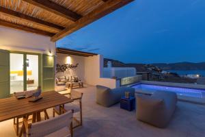 a patio with a table and chairs and a pool at Mykonos Panormos Villas in Panormos Mykonos