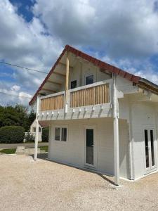 a house with a balcony on top of it at Chalet 6-8 personnes avec jeux et jaccuzi - Nahleo Chalet in Villers-lès-Pots