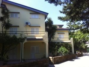 ein gelbes und weißes Haus mit einem Zaun davor in der Unterkunft praialinda in Badolato