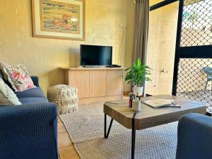 a living room with a couch and a tv at Riverview Holiday Apartment 92 - Kalbarri WA in Kalbarri