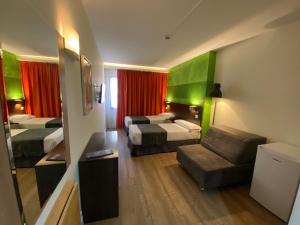 a hotel room with two beds and a couch at Apartamentos Recoletos in Madrid