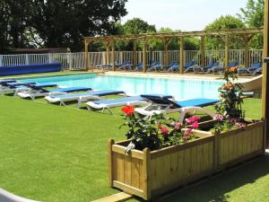 a swimming pool with chairs and flowers next to it at BAHIA LUXE in Limeuil