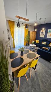 Apartamenty Nowickiego في لوبلين: غرفة معيشة مع طاولة وكراسي صفراء