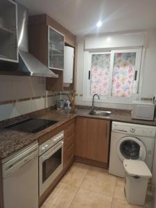 a kitchen with a sink and a washing machine at Jardines del Mar in Oropesa del Mar