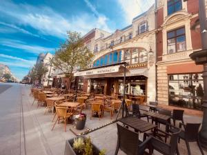 罗兹Apartament I LOVE PIOTRKOWSKA z wielkim lustrem, balkonem i klimatyzacją的城市街道上一排桌椅