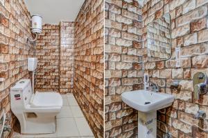 een badkamer met een bakstenen muur, een toilet en een wastafel bij FabHotel Jimmy Palace in Tājganj