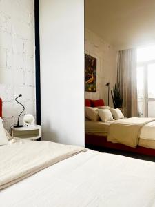 1 dormitorio con 2 camas y pared de ladrillo blanco en Apartament I LOVE PIOTRKOWSKA z wielkim lustrem, balkonem i klimatyzacją, en Łódź