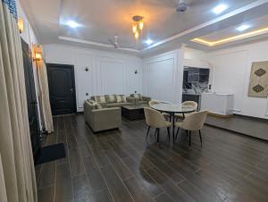 Adventure Techie Resort في اسلام اباد: غرفة معيشة مع أريكة وطاولة وكراسي