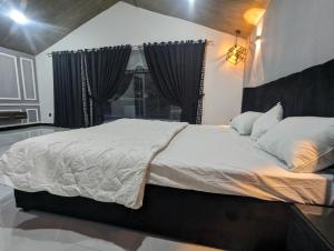 1 cama grande en un dormitorio con ventana en Adventure Techie Resort en Islamabad