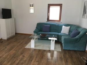 a living room with a green couch and a table at Mosel Ferienwohnung in Ürzig