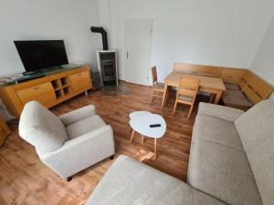 a living room with two couches and a table and a television at Ferienwohnung Am Straussee in Strausberg