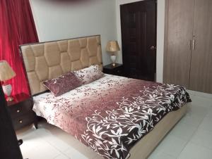 1 dormitorio con 1 cama con edredón blanco y negro en Balqees Cottage en Lahore