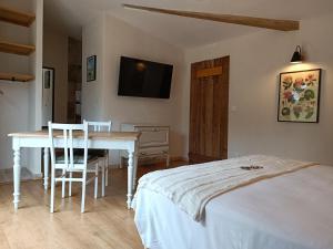 a bedroom with a bed and a table and a television at La Tour du Laurensou in Figeac