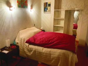 sypialnia z czerwonym łóżkiem i lustrem w obiekcie L'Escapade de JOS gite équestre w mieście Pont-de-Salars