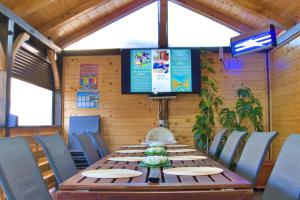 a dining room with a table and a television at CĂSUȚA LUI ION in Sulina