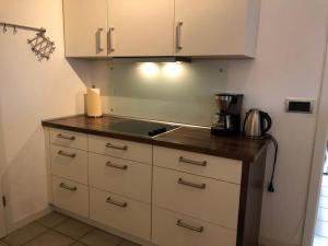 a kitchen with white cabinets and a counter top at Ferienwohnung Am Flörbach in Ahaus