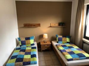 a room with two beds and a table with a lamp at Ferienwohnung Am Flörbach in Ahaus +4 photos