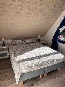 ein Bett in einem Zimmer mit Holzdecke in der Unterkunft DOMIKO in Mikoszewo