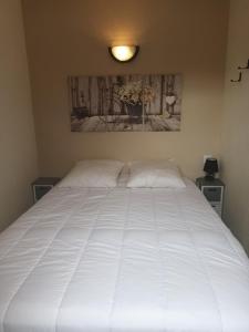 uma grande cama branca com duas almofadas em Corrèze rive Dordogne em Argentat