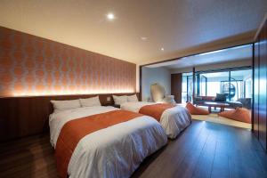 Hotel Higashidate في يامانوتشي: غرفة فندقية بسريرين ومكتب