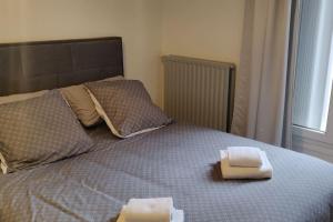 un letto con due asciugamani sopra di Cosy Appartement Paris Ouest a Suresnes